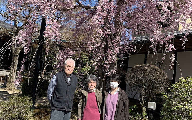 大きな桜の木の前での笑顔